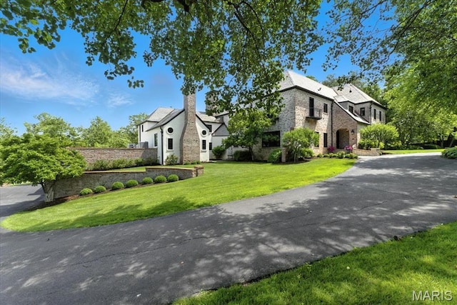 32 Woodoaks Trl, Ladue, MO 63124 - view of front of house with a front yard, asphalt driveway, and stone siding