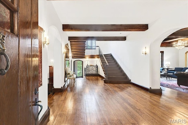 32 Woodoaks Trl, Ladue, MO 63124 - foyer entrance featuring arched walkways, beam ceiling, stairway, and hardwood / wood-style flooring