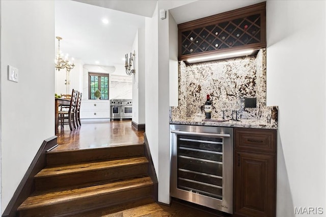 32 Woodoaks Trl, Ladue, MO 63124 - indoor dry bar featuring wine cooler, tasteful backsplash, a chandelier, wood finished floors, and recessed lighting