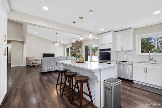 4163 Attleboro Ct, Saint Charles, MO 63304 - kitchen featuring appliances with stainless steel finishes, a sink, white cabinets, a center island, and backsplash