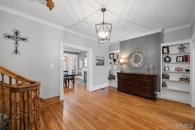 232 N Newstead Ave, Saint Louis, MO 63108 - entrance foyer with a chandelier, light wood-style floors, ornamental molding, and baseboards