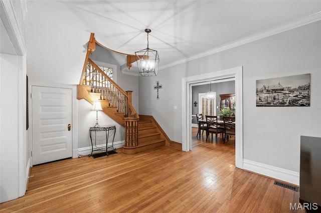232 N Newstead Ave, Saint Louis, MO 63108 - entrance foyer featuring a chandelier, stairway, baseboards, light wood-type flooring, and ornamental molding