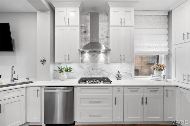 232 N Newstead Ave, Saint Louis, MO 63108 - kitchen featuring wall chimney exhaust hood, stainless steel appliances, a sink, and white cabinets
