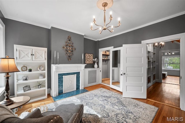 232 N Newstead Ave, Saint Louis, MO 63108 - living room featuring a chandelier, crown molding, wood finished floors, and a fireplace