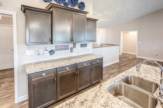 3772 Osprey Ct, Shiloh, IL 62221 - kitchen with a sink, light wood-style flooring, vaulted ceiling, baseboards, and dark brown cabinetry