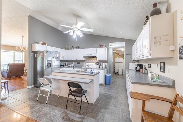 2865 Vaughn Ave, Poplar Bluff, MO 63901 - kitchen featuring stainless steel fridge with ice dispenser, lofted ceiling, a ceiling fan, under cabinet range hood, and a center island with sink
