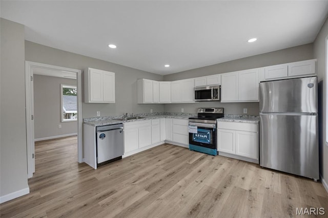 812 Richeson Rd, Potosi, MO 63664 - kitchen featuring appliances with stainless steel finishes, light stone counters, white cabinets, light wood-type flooring, and recessed lighting