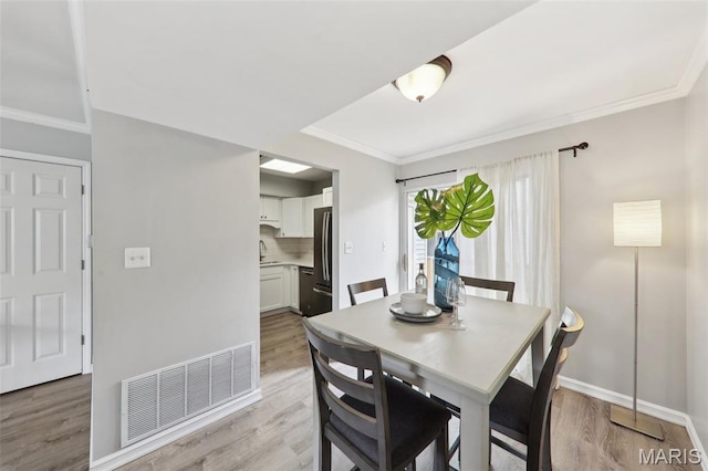 8854 Flamingo Ct, Saint Louis, MO 63144 - dining area with ornamental molding, light wood-type flooring, and baseboards