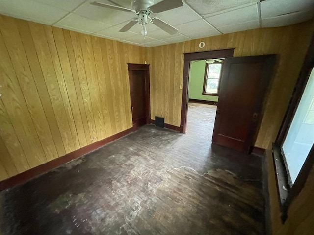 20621 County Highway 22, Hoyleton, IL 62803 - spare room featuring a paneled ceiling, a ceiling fan, wooden walls, and baseboards
