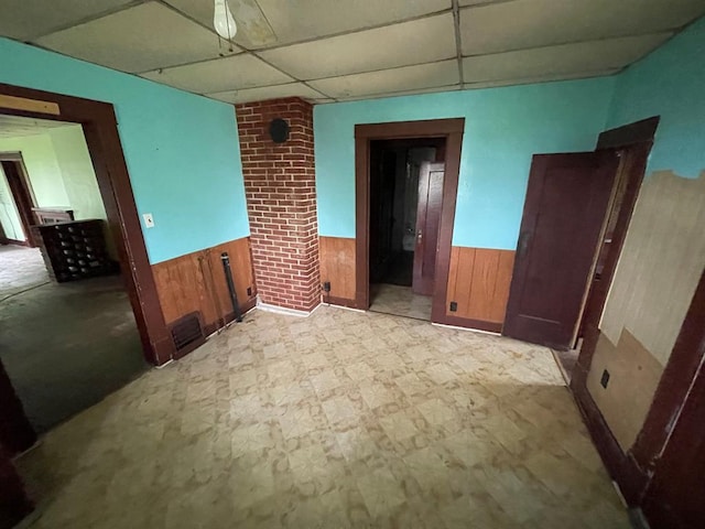 20621 County Highway 22, Hoyleton, IL 62803 - unfurnished room with a paneled ceiling, wainscoting, wooden walls, and tile patterned floors