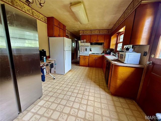 905 Dewitt St, Hannibal, MO 63401 - kitchen with black appliances, light flooring, light countertops, a sink, and brown cabinets
