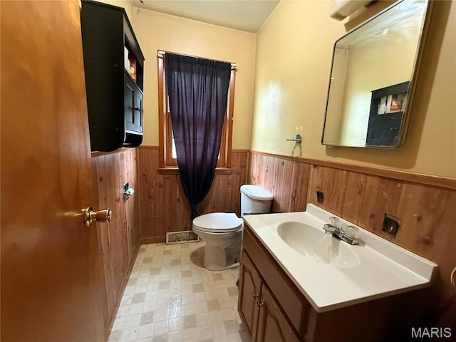 905 Dewitt St, Hannibal, MO 63401 - bathroom featuring a wainscoted wall, toilet, vanity, wood walls, and tile patterned floors