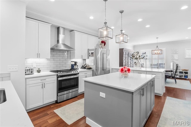 7723 Dale Ave, Richmond Heights, MO 63117 - kitchen featuring wall chimney range hood, stainless steel appliances, light countertops, a kitchen island, and recessed lighting