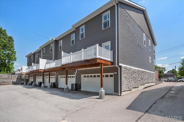 7723 Dale Ave, Richmond Heights, MO 63117 - back of property with stone siding, a garage, and cooling unit