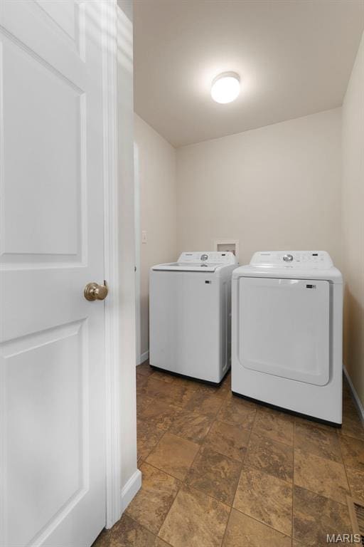 119 Hidden Bluffs Dr, Lake St Louis, MO 63367 - laundry room featuring washer and clothes dryer and stone finish floors