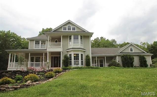 1519 Scofield Valley Ln, Wildwood, MO 63038 - rear view of house with a balcony, a lawn, and a porch