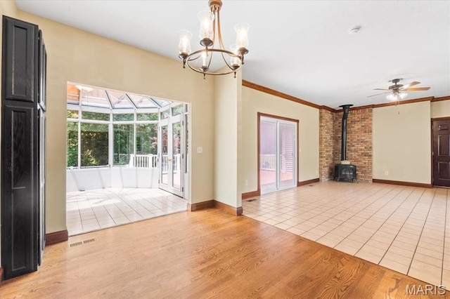 1519 Scofield Valley Ln, Wildwood, MO 63038 - unfurnished living room featuring a wood stove, a ceiling fan, a chandelier, light tile patterned floors, and crown molding