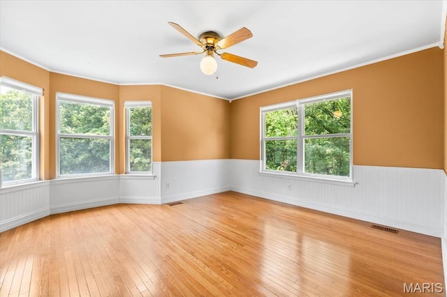1519 Scofield Valley Ln, Wildwood, MO 63038 - empty room with wainscoting, light wood-style floors, healthy amount of natural light, ceiling fan, and crown molding