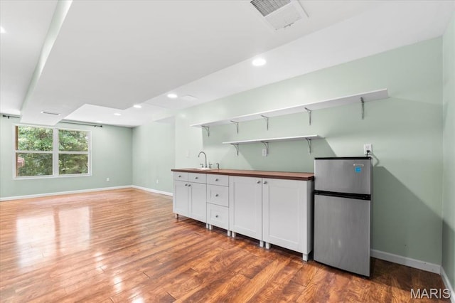 1519 Scofield Valley Ln, Wildwood, MO 63038 - kitchen featuring freestanding refrigerator, butcher block countertops, white cabinetry, wood finished floors, and open shelves