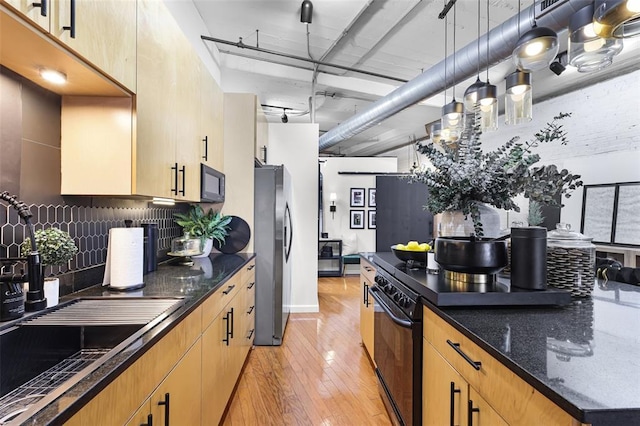 1619 Washington Ave Unit 505, Saint Louis, MO 63103 - kitchen featuring freestanding refrigerator, wall oven, a sink, black microwave, and decorative backsplash