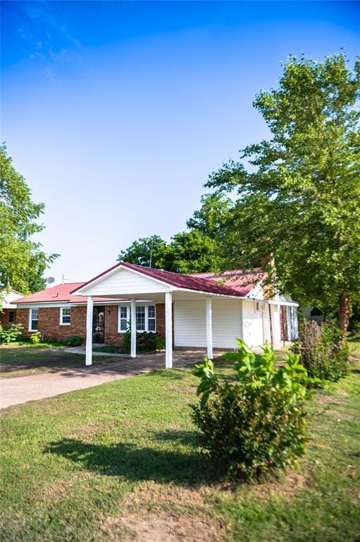 216 Patty Lynn Dr, Kennett, MO 63857 - ranch-style home featuring driveway, a front yard, an attached carport, and metal roof