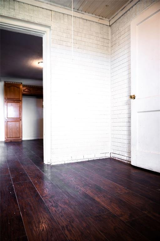 216 Patty Lynn Dr, Kennett, MO 63857 - empty room featuring brick wall and dark wood-style flooring