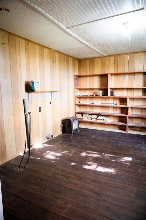 216 Patty Lynn Dr, Kennett, MO 63857 - empty room with wooden walls and dark wood finished floors