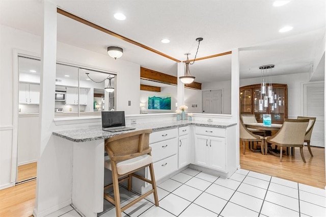 15017 Baxter Vlg Unit B, Chesterfield, MO 63017 - kitchen featuring white cabinets, pendant lighting, light stone countertops, light wood-style flooring, and recessed lighting