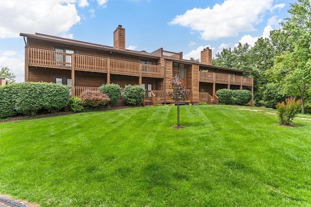 15017 Baxter Vlg Unit B, Chesterfield, MO 63017 - back of property featuring a chimney, a lawn, and a balcony