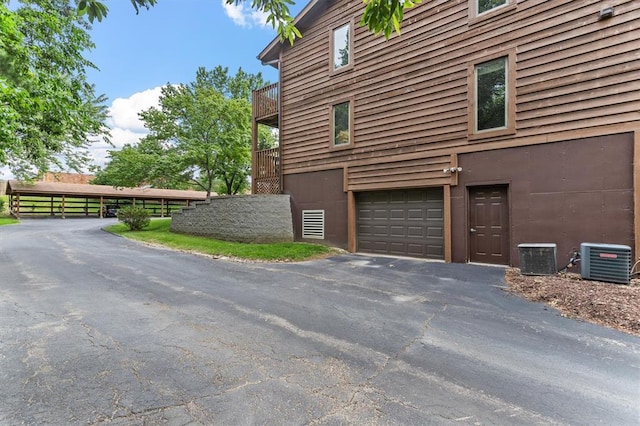 15017 Baxter Vlg Unit B, Chesterfield, MO 63017 - view of property exterior with cooling unit, asphalt driveway, a balcony, and a garage