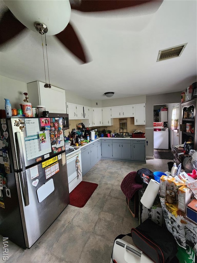 1520 Flicker Dr, Florissant, MO 63031 - kitchen featuring freestanding refrigerator, white range oven, white cabinets, light countertops, and a sink