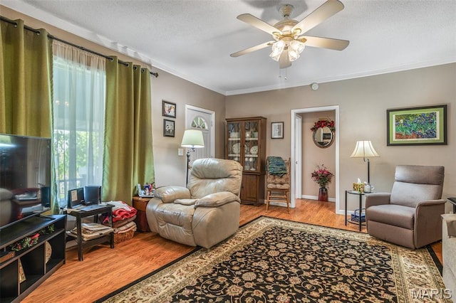 406 N Division St, Bonne Terre, MO 63628 - living room featuring wood finished floors, a ceiling fan, crown molding, baseboards, and a textured ceiling
