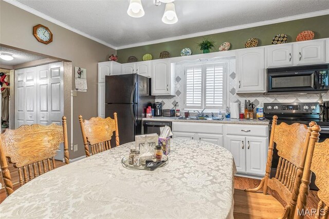 406 N Division St, Bonne Terre, MO 63628 - kitchen featuring black appliances, light countertops, a sink, white cabinetry, and crown molding