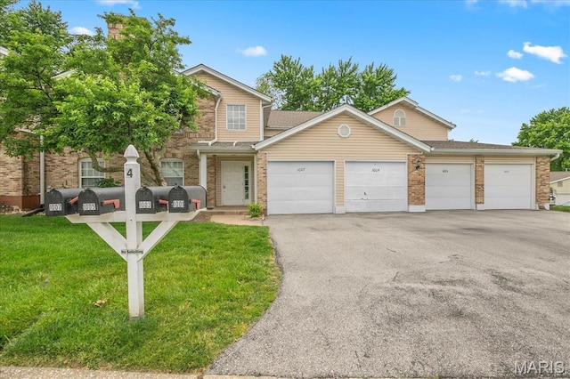 1001 Windstream Dr Unit 32, Saint Peters, MO 63376 - view of front facade with a garage, driveway, brick siding, a front yard, and a shingled roof