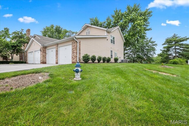 1001 Windstream Dr Unit 32, Saint Peters, MO 63376 - view of property exterior featuring a garage, a yard, concrete driveway, brick siding, and cooling unit