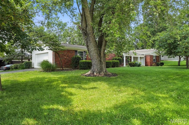 1214 Iron Warrior Ln, Ballwin, MO 63011 - view of green lawn featuring a garage and asphalt driveway