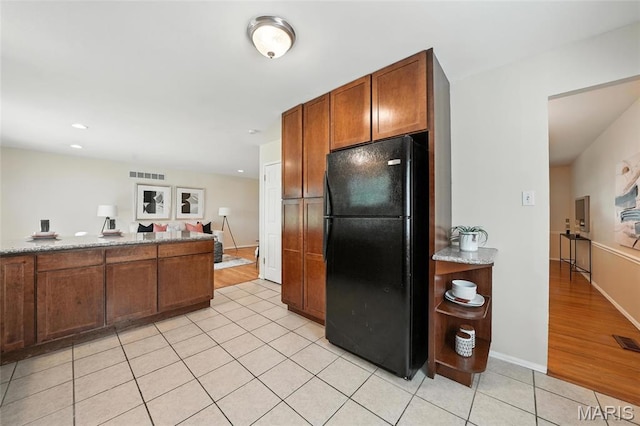 1214 Iron Warrior Ln, Ballwin, MO 63011 - kitchen with freestanding refrigerator, light tile patterned floors, brown cabinetry, and recessed lighting