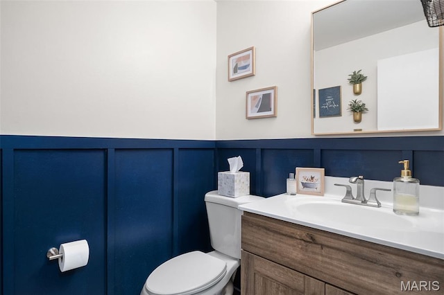 621 Sugar Trail Ct Unit 4, Saint Peters, MO 63376 - half bathroom featuring a decorative wall, toilet, vanity, and a wainscoted wall