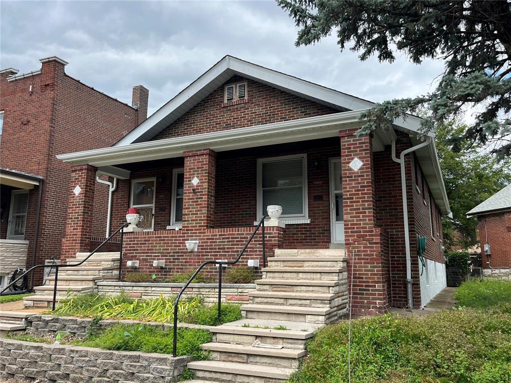 6005 Carlsbad Ave, Saint Louis, MO 63116 - view of front facade featuring a porch, brick siding, and a chimney
