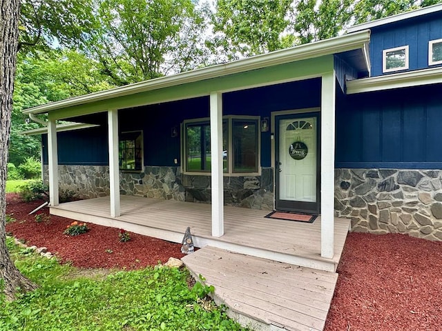 12185 Oak Meadow Dr, Rolla, MO 65401 - view of exterior entry with stone siding, a porch, and board and batten siding