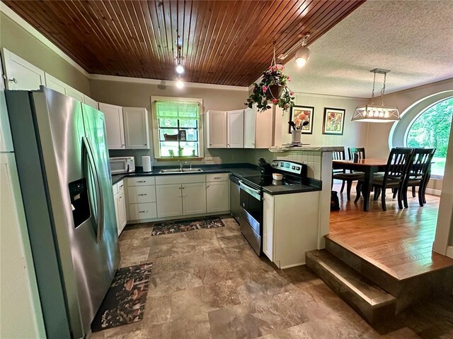 12185 Oak Meadow Dr, Rolla, MO 65401 - kitchen featuring appliances with stainless steel finishes, a sink, dark countertops, white cabinetry, and decorative light fixtures