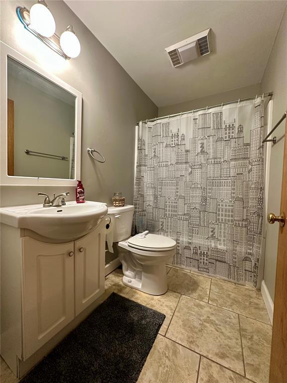 12185 Oak Meadow Dr, Rolla, MO 65401 - bathroom featuring toilet, vanity, tile patterned floors, and a shower with curtain