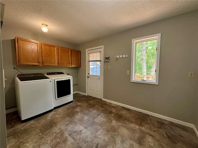 12185 Oak Meadow Dr, Rolla, MO 65401 - laundry area featuring washer and dryer, cabinet space, plenty of natural light, baseboards, and a textured ceiling