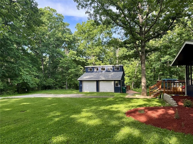 12185 Oak Meadow Dr, Rolla, MO 65401 - view of green lawn with an outdoor structure, a garage, view of wooded area, and a playground