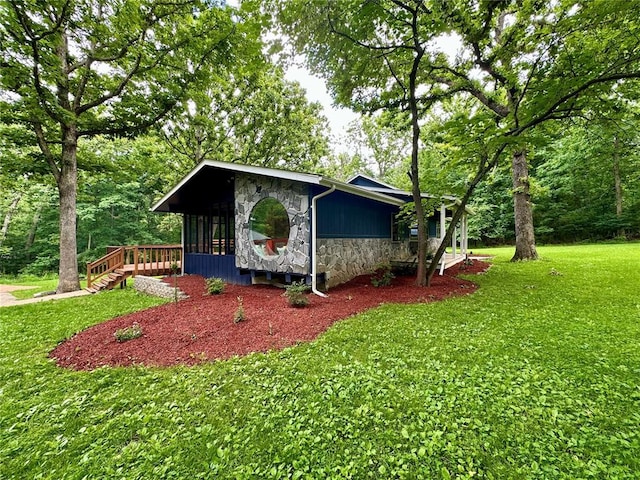 12185 Oak Meadow Dr, Rolla, MO 65401 - view of front of house featuring stone siding, a front yard, and a sunroom