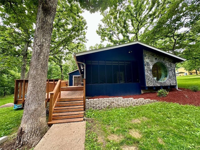 12185 Oak Meadow Dr, Rolla, MO 65401 - view of front of property featuring a sunroom, a wooden deck, a front yard, stone siding, and stairs