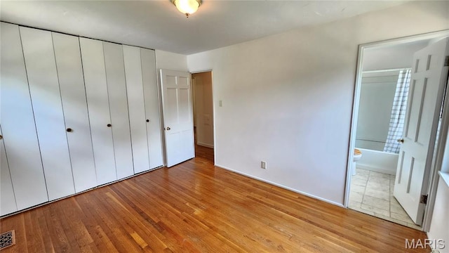 9117 Tiber Ct, Affton, MO 63123 - unfurnished bedroom with light wood finished floors, a closet, and connected bathroom