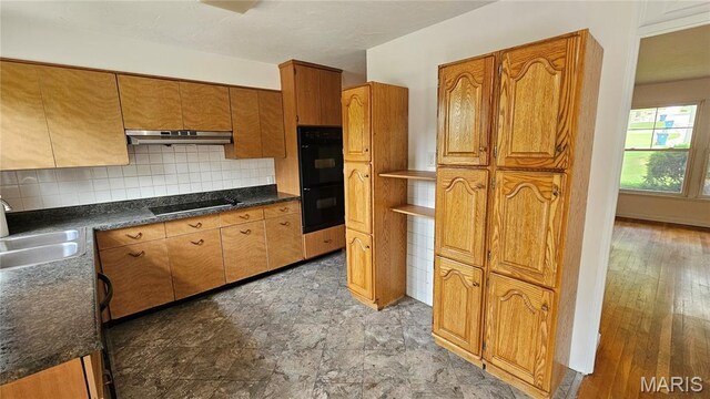 9117 Tiber Ct, Affton, MO 63123 - kitchen with black appliances, brown cabinets, under cabinet range hood, decorative backsplash, and dark countertops