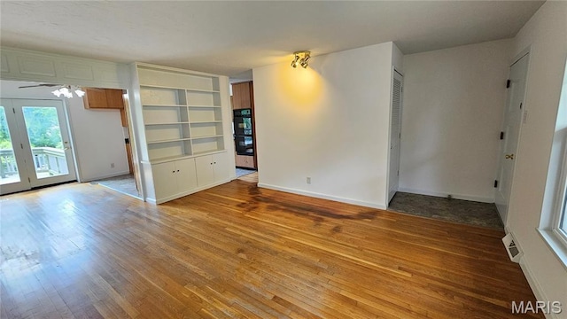 9117 Tiber Ct, Affton, MO 63123 - spare room with wood-type flooring, ceiling fan, and built in shelves
