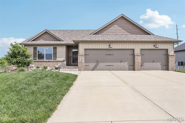 520 W 5th St, Saint Jacob, IL 62281 - view of front of home with a garage, brick siding, concrete driveway, a front yard, and roof with shingles